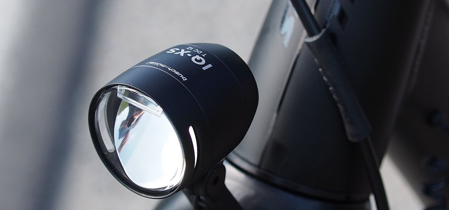 Schwarzer LED-Fahrradscheinwerfer am silbernen Fahrradlenker montiert.